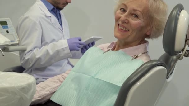 女性客户端显示她的拇指在牙科椅 — 图库视频影像