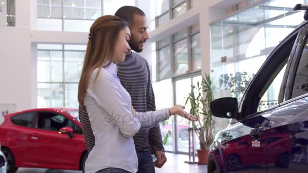 Pareja elige el coche en el concesionario — Vídeo de stock