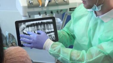 Diş hekimi x-ray görüntü onun tablet üzerinde taşır.
