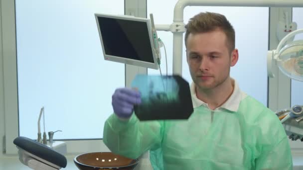 Dentysta podnosi x-ray do światła — Wideo stockowe