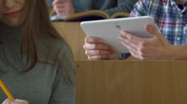 Erkek öğrenci onun sınıf arkadaşı bir şey tablete gösterir