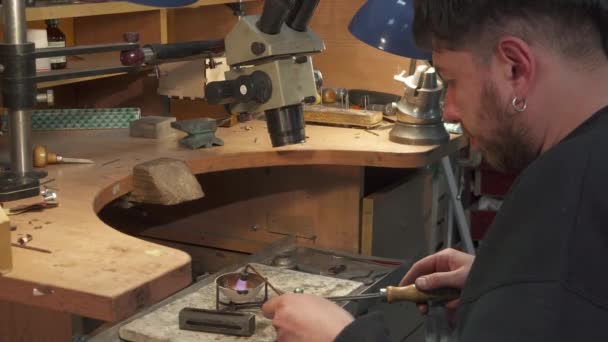 Jeweler direct the gas torch into the crucible — Stock Video