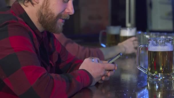 Чоловік використовує мобільний телефон у пабі — стокове відео