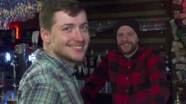 Adam bir bardak bira barda gösterir