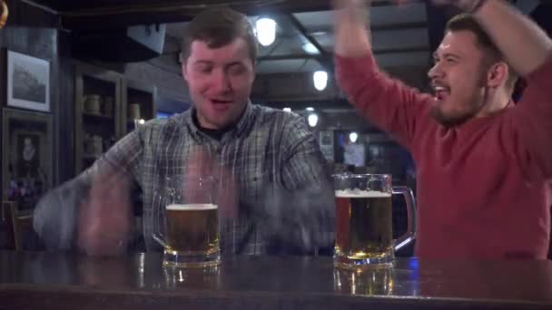 Amigos celebran el éxito de su equipo en el pub — Vídeos de Stock