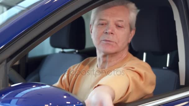 Senior blickt in den Seitenspiegel des Autos — Stockvideo