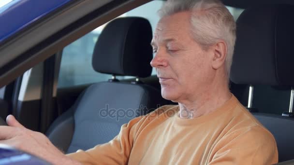 Senior man shows car key through the window — Stock Video