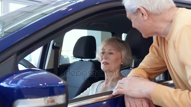 Pareja mayor posa con el coche en el concesionario — Vídeos de Stock