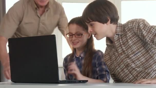 Seniorchef und seine Enkel unterhalten am Laptop — Stockvideo