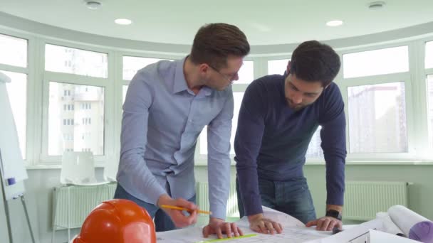 Два архитектора работают над проектом в офисе — стоковое видео