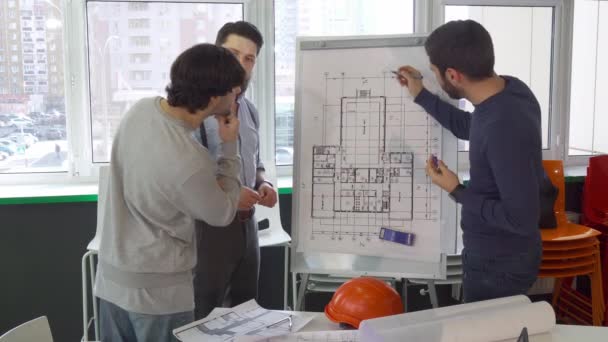 Architecte expliquant quelque chose sur le plan du bâtiment à ses collègues — Video