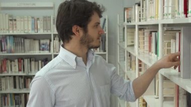 Adam bir kitap kütüphanede arar