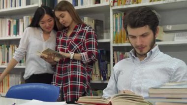 Erkek öğrencilerin kütüphanede kitap okur