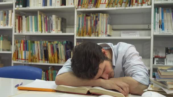 O tipo dorme na biblioteca. — Vídeo de Stock