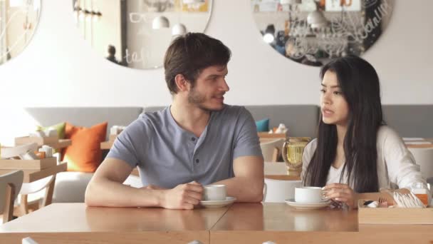Chica le dice algo a su amigo en el café — Vídeos de Stock