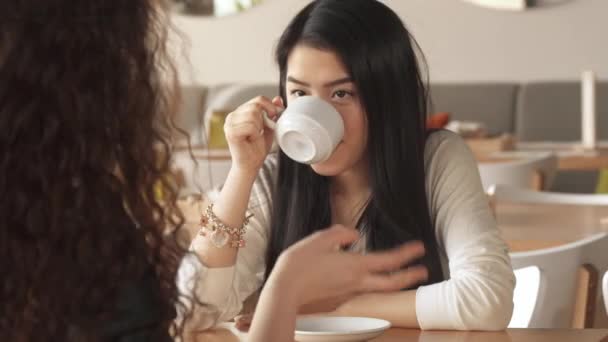 Menina ri sobre o que seu amigo dizendo no café — Vídeo de Stock