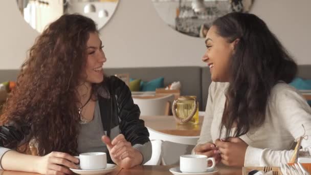 Две девушки смеются в кафе — стоковое видео