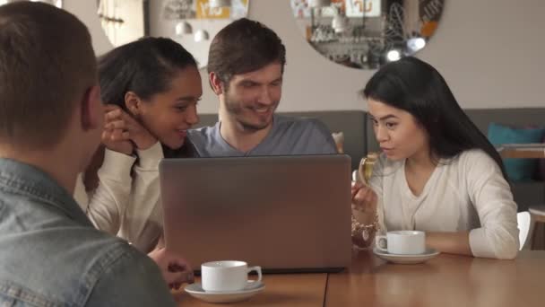 Vänner titta på något på laptop på café — Stockvideo