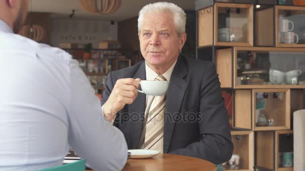 Старший бизнесмен слушает своего партнера — стоковое видео