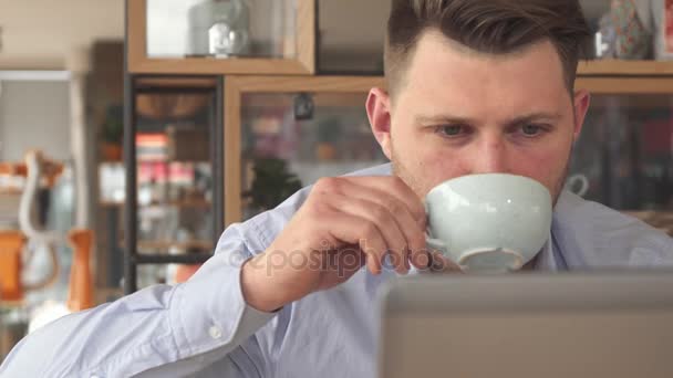 Молодий бізнесмен п'є каву в кафе — стокове відео