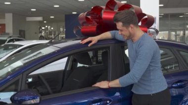 Erkek müşteri parmağını arabanın yakınında ortaya