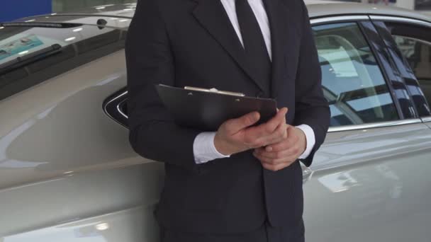 Försäljningschef pekar hans hand på bilen — Stockvideo