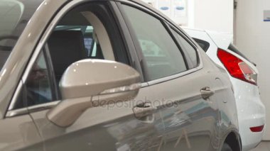 Adam araba galerisinde inceliyor