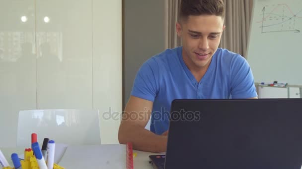 Парень работает на ноутбуке в офисе — стоковое видео
