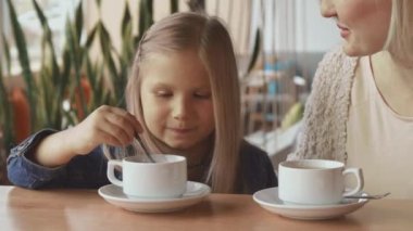 Küçük kız kaşık Kupası'na taşır.