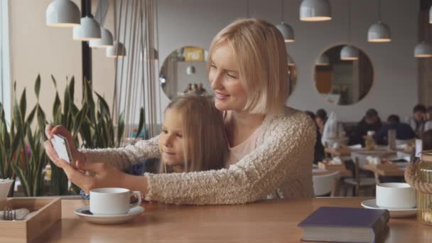 Femme prend un selfie avec sa fille au café — Video