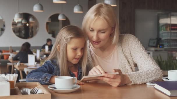 Мати і дочка дивляться меню — стокове відео