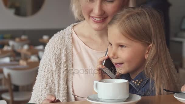 Kis lány beszél a telefonon a Café — Stock videók