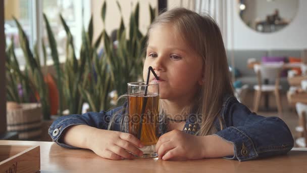 Niña beba un poco de agua con sabor en el café — Vídeo de stock