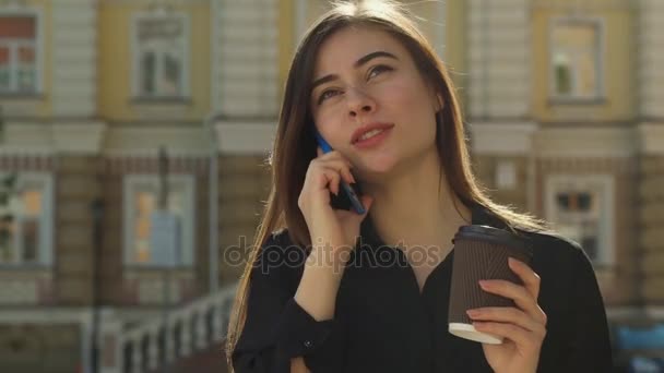 Девушка разговаривает по телефону на улице города — стоковое видео