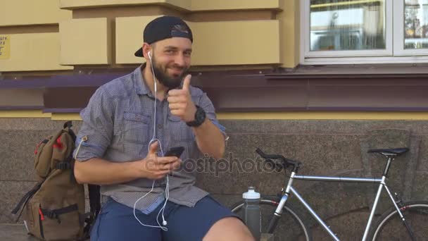 Ciclista muestra su pulgar en la calle — Vídeos de Stock