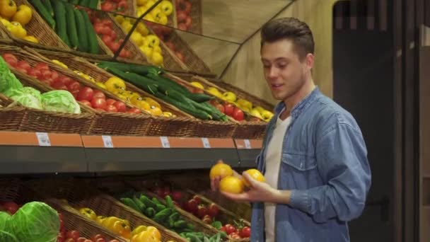 Guy compra frutas e legumes no hipermercado — Vídeo de Stock