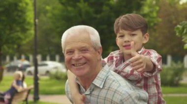 Küçük çocuk başparmaklarını dedeler sırtında ortaya çıktı