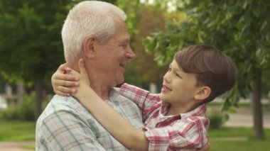 Küçük çocuk onun ellerini dedeler boynunun tutar.