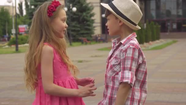 Mały chłopiec i dziewczynka mówić na zewnątrz — Wideo stockowe
