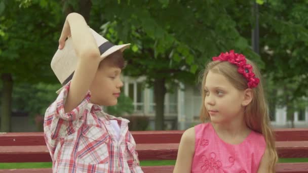 Glimlach van de kinderen voor elkaar op de Bank — Stockvideo