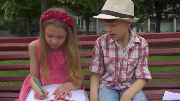 Kleines Mädchen zeichnet im Album auf der Bank — Stockvideo