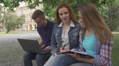 Kız öğrenci onu egzersiz kitap kampüste yazıyor.