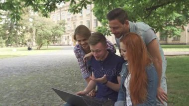 Dört öğrenciler kampüste laptop gördükleri gülmek