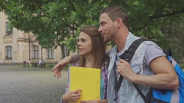 Erkek öğrenci onun sınıf arkadaşı kampüste kucaklayan