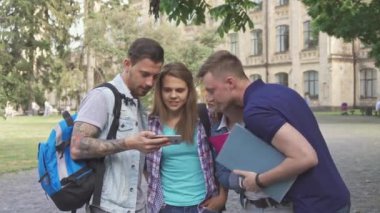 Dört öğrenciler kampüste smartphone ekrana bak