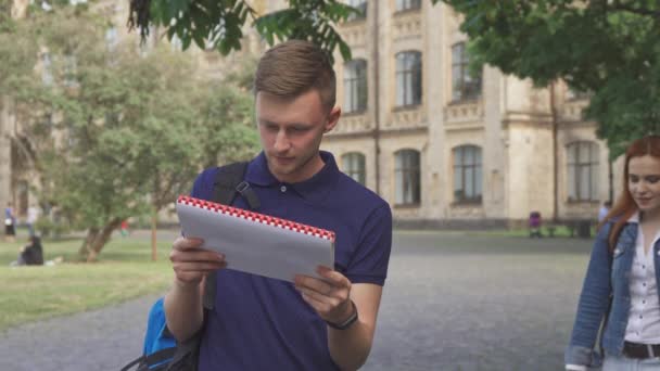 Студентка закрывает своим друзьям глаза на кампус — стоковое видео