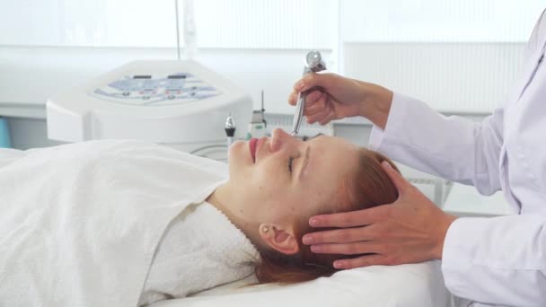 Cosmetologist usando alguns equipamentos no rosto dos clientes — Vídeo de Stock