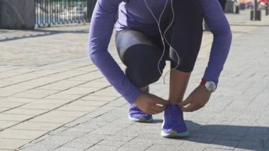 Kadın spor ayakkabı üzerinde dize düzeltmek için durur