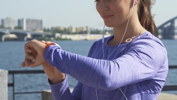 Vrouw gebruikt haar horloges bij de riverwalk — Stockvideo