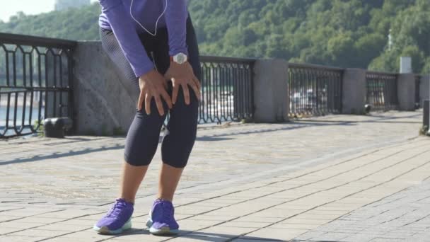 Kvinna gör övningar för benen på flodpromenaden — Stockvideo